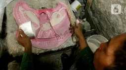 Perajin menyelesaikan pembuatan patung Garuda Pancasila yang terbuat dari serat kaca (fiberglas) di kawasan Kalimalang, Jakarta Timur, Selasa (16/8/2022). Patung Garuda Pancasila dijual dengan harga Rp 300 ribu hingga Rp 3 juta. (merdeka.com/Arie Basuki)