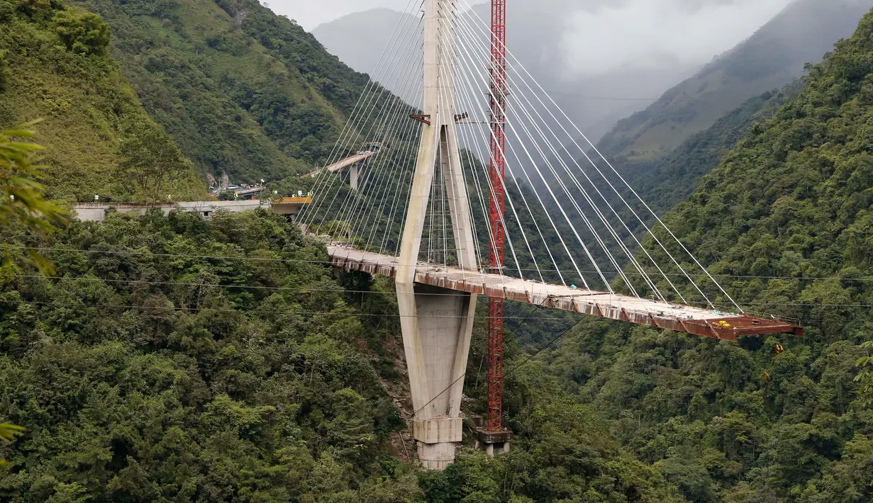 Penampakan sebuah jembatan gantung sebelum dihancurkan oleh para insinyur di Chirajara, Kolombia, Rabu (11/7). Sebelumnya, sebagian jembatan runtuh dan menewaskan sembilan pekerja saat pembangunannya pada Januari lalu. (AP Photo/Fernando Vergara)
