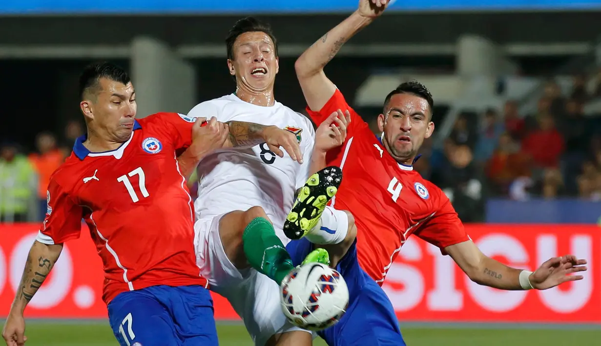 Gelandang Bolivia, Martin Smedeberg berusaha melewati dua pemain Chile saat pertandingan Copa Amerika 2015 di Estadio Nacional, Santiago, Chile, (20/6/2015). Chile menang telak 5-0 atas Bolivia. (REUTERS/Henry Romero)