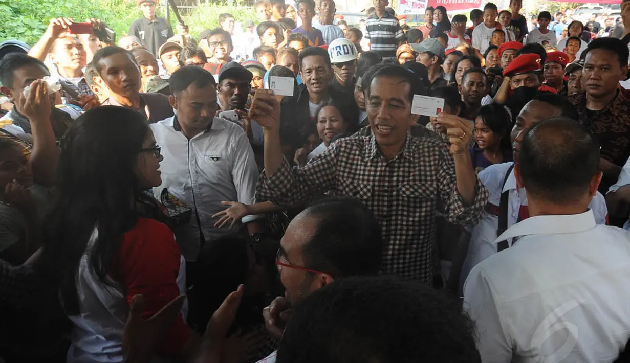 Gubernur DKI Jakarta non aktif tersebut menunjukkan Kartu Indonesia Pintar dan Kartu Indonesia Sehat saat berdialog di Kampung Nelayan Indah, Medan, Selasa (10/6/14). (Liputan6.com/Herman Zakharia)