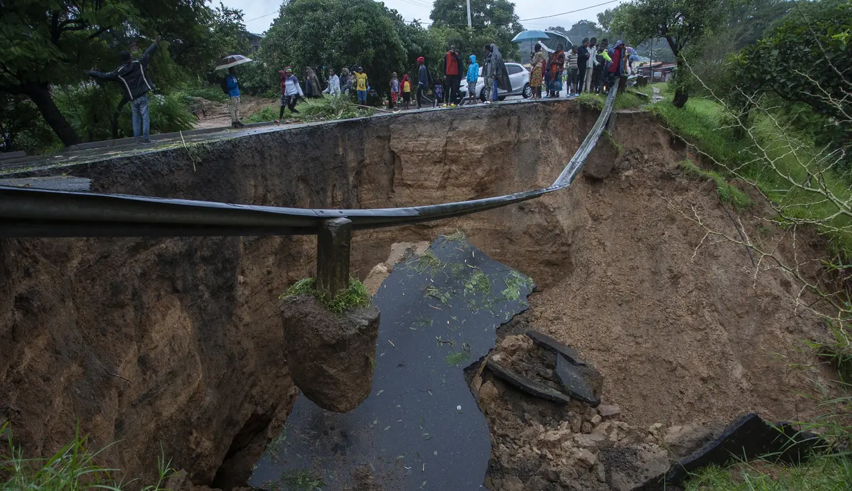 Jalan yang runtuh akibat banjir akibat hujan lebat menyusul topan Freddy di Blantyre, Malawi, pada 13 Maret 2013. Freddy, di jalur untuk menjadi badai terlama dalam catatan, meluncur melalui Afrika selatan pada akhir pekan untuk kedua kalinya dalam beberapa minggu, kembali setelah pukulan pertama pada akhir Februari. (AFP/Amos Gumulira)
