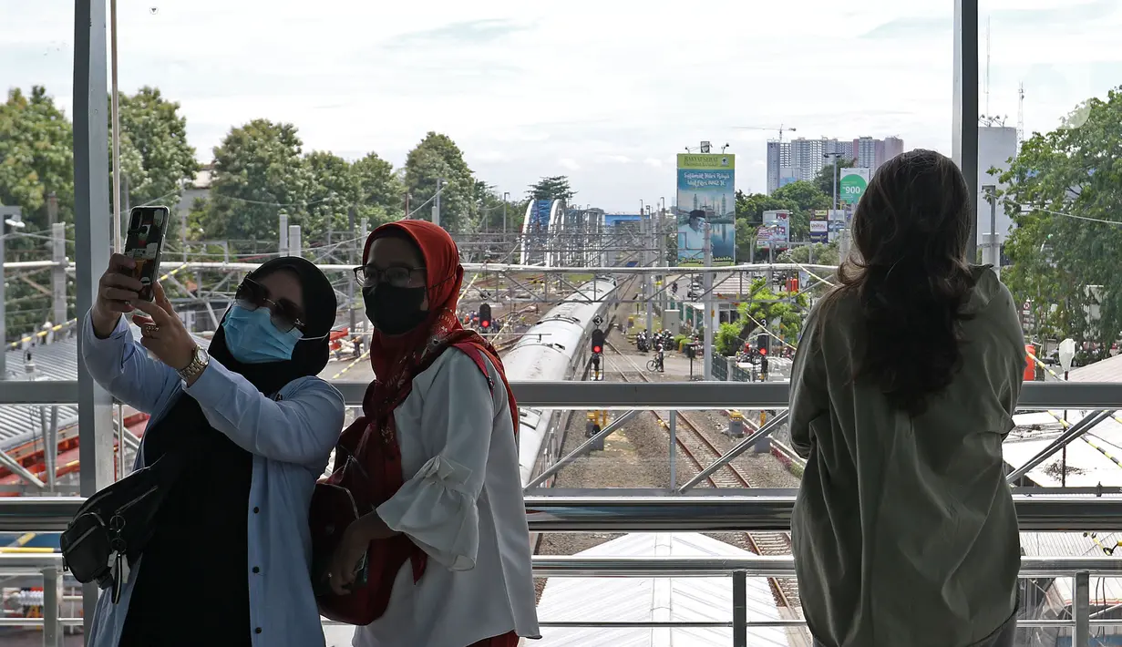 Penumpang berswafoto di Stasiun Bekasi, Kota Bekasi, Jawa Barat, Selasa (23/11/2021). Pengaktifan bangunan baru dan penonaktifan jalur 1, 2, dan 3 di area bangunan lama merupakan tahapan dalam revitalisasi Stasiun Bekasi. (Liputan6.com/Herman Zakharia)