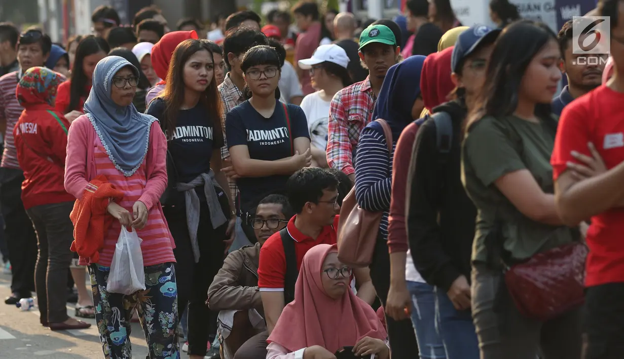 Calon penonton antre untuk mendapatkan tiket final bulu tangkis beregu putra di sekitar tiket boks di kawasan GBK, Jakarta, Rabu (22/8). Laga final bulu tangkis beregu putra mempertemukan Indonesia melawan China. (Liputan6.com/Helmi Fithriansyah)