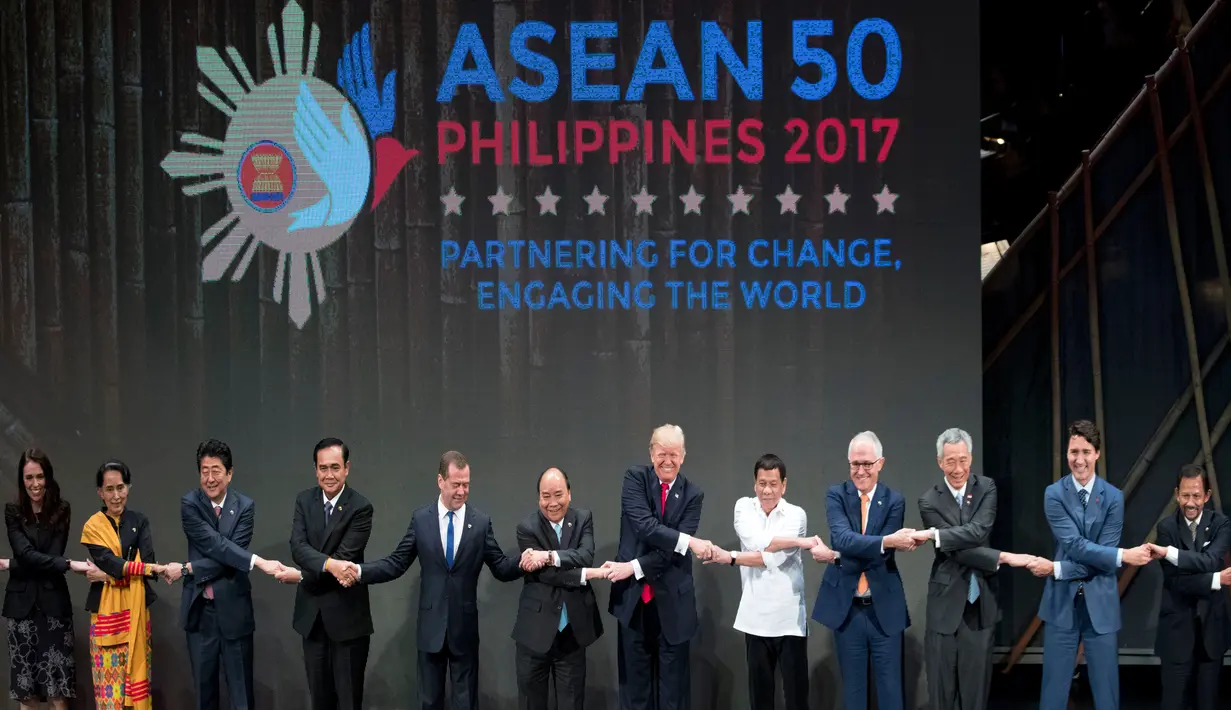 Presiden AS, Donald Trump dan para pemimpin lainnya melakukan salaman khas ASEAN di penghujung upacara pembukaan KTT ASEAN di Manila, Filipina, Senin (13/11). Trump sempat kesulitan menempatkan tangannya di posisi yang pas. (AP/Andrew Harnik)