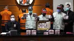 Petugas menunjukkan barang bukti pada jumpa pers Operasi Tangkap Tangan (OTT) Gubernur Sulawesi Selatan di gedung KPK, Jakarta, Minggu (28/2/2021) dini hari. KPK menyita koper berisi Rp 2 Miliar dalam OTT terhadap Gubernur Sulawesi Selatan Nurdin Abdullah. (Liputan6.com/Herman Zakharia)