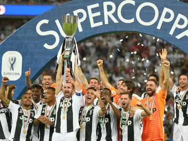 Pemain Juventus, Giorgio Chiellini mengangkat trofi Piala Super Italia 2018 seusai mengalahkan AC Milan pada laga final di King Abdullah Sports City, Kamis (17/1). Juventus keluar sebagai kampiun dengan meraih kemenangan tipis 1-0. (AP Photo)