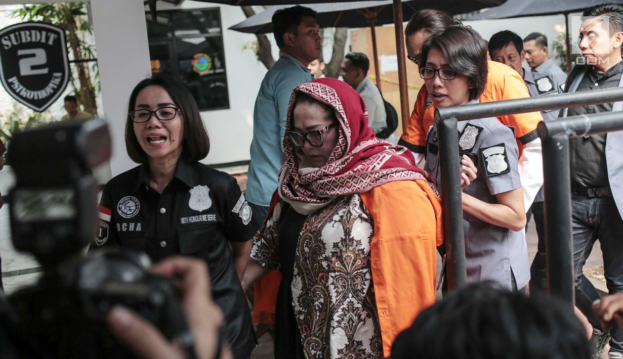 Petugas menggiring komedian Tri Retno Prayudati alias Nunung sebelum rilis kasus narkoba di Ditnarkoba Polda Metro Jaya, Jakarta, Senin (22/7/2019). Nunung ditangkap bersama suaminya, July Jan Sambiran, usai bertransaksi narkoba dengan tersangka TB di kediaman mereka. (Liputan6.com/Faizal Fanani)