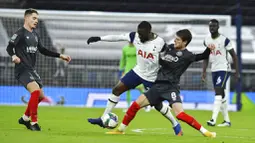 Pemain Tottenham Hotspur, Tanguy Ndombele, berusaha melewati pemain Brentford, Mathias Jensen, pada laga Piala Liga Inggris, di London, Rabu (06/01/2021). Spurs menang dengan skor 2-0. (Glyn Kirk/Pool via AP)