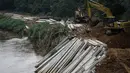 Pekerja dibantu alat berat membuat turap beton dialiran kali Ciliwung-Condet, Jakarta. Foto diambil pada Senin (10/11/2014). (Liputan6.com/Faizal Fanani) 