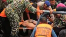Tim SAR membawa penumpang korban helikopter jatuh yang selamat, Fransiskus Subihardayan (tengah) usai ditemukan mengapung di Danau Toba, Sumatera, Selasa (13/10). Pria itu mengapung setelah dua hari helikopter EC 130 hilang kontak. (AFP PHOTO)