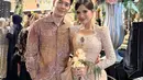 Pasangan Audi Marissa dan Anthony Xie juga tampil kompak dengan warna-warna lembut yang elegan. Audi mengenakan kebaya bridesmaid berwarna nude rancangan desainer Renzi Lazuardi. Kebaya ini memiliki detail kerah u-neck, lengan bahu puffed, serta aksen draped di bagian pinggang yang memberikan siluet menawan. [@audimarissa]