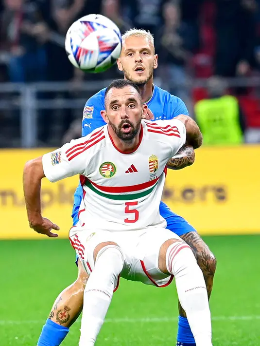 Pemain Hungaria Attila Fiola (depan) berebut bola dengan pemain Italia Federico Dimarco pada pertandingan sepak bola UEFA Nations League di Puskas Arena, Budapest, Hungaria, 26 September 2022. Italia berhasil mengalahkan Hungaria dengan skor 2-0. (Tamas Kovacs/MTI via AP)