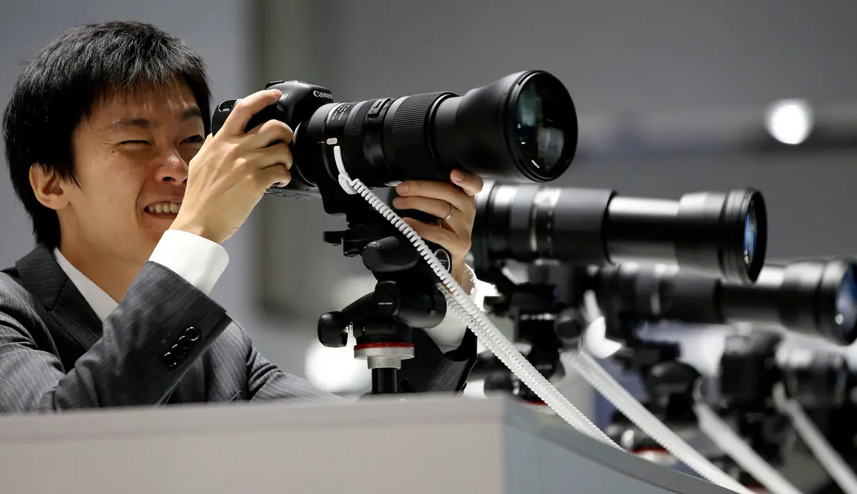 Pengunjung mencoba mengoperasikan lensa kamera Tamron di stand Tamron saat berlangsungnya Pameran Photokina di Cologne, Jerman, (20/9). Pameran ini berlangsung 20-25 September 2016. (REUTERS/Fabrizio Bensch)