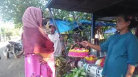 Nuraeni, pedagang bunga tertua di TPU Panaikang sedang tawarkan bunga ke peziarah (Liputan6.com/ Eka Hakim)