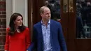 Pangeran William dan Kate Middleton bergandengan tangan saat meninggalkan Rumah Sakit St Mary's di London, Senin (23/4). Di luar dugaan, William dan Kate yang berniat untuk kembali ke Kensington Palace memamerkan kemesraannya. (AP/Kirsty Wigglesworth)
