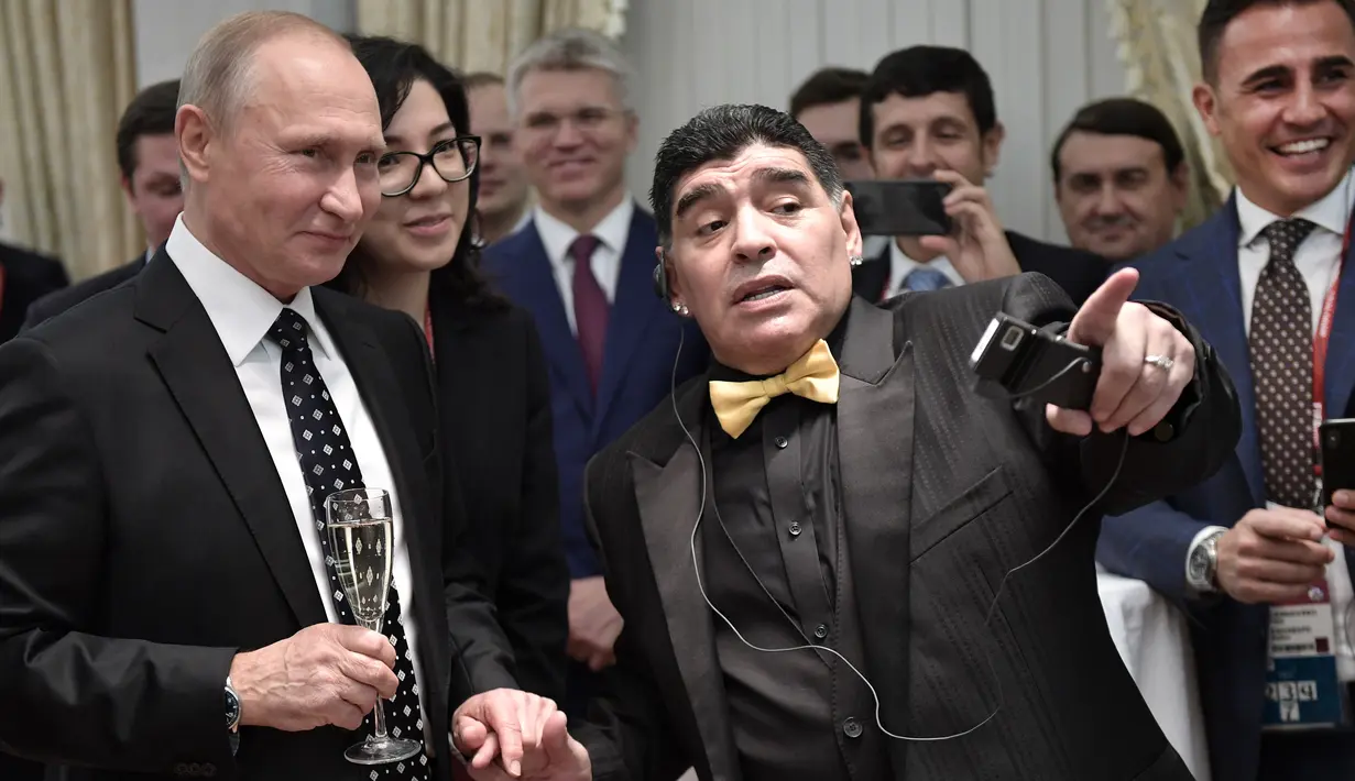 Presiden Rusia Vladimir Putin (kiri) berbincang dengan legenda sepak bola Argentina, Diego Maradona saat menghadiri undian Piala Dunia 2018 di Moskow, Rusia (1/12). (AFP Photo/Sputnik/Alexey Nikolsky)