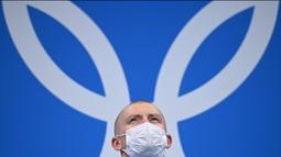 Atlet renang asal Inggris, Adam Peaty berdiri di podium saat akan menerima medali emas usai pertandingan final gaya dada 100m renang putra Olimpiade Tokyo 2020 di Tokyo Aquatics Center, Senin (26/7/2021). (Foto: AFP/Oli Scarff)