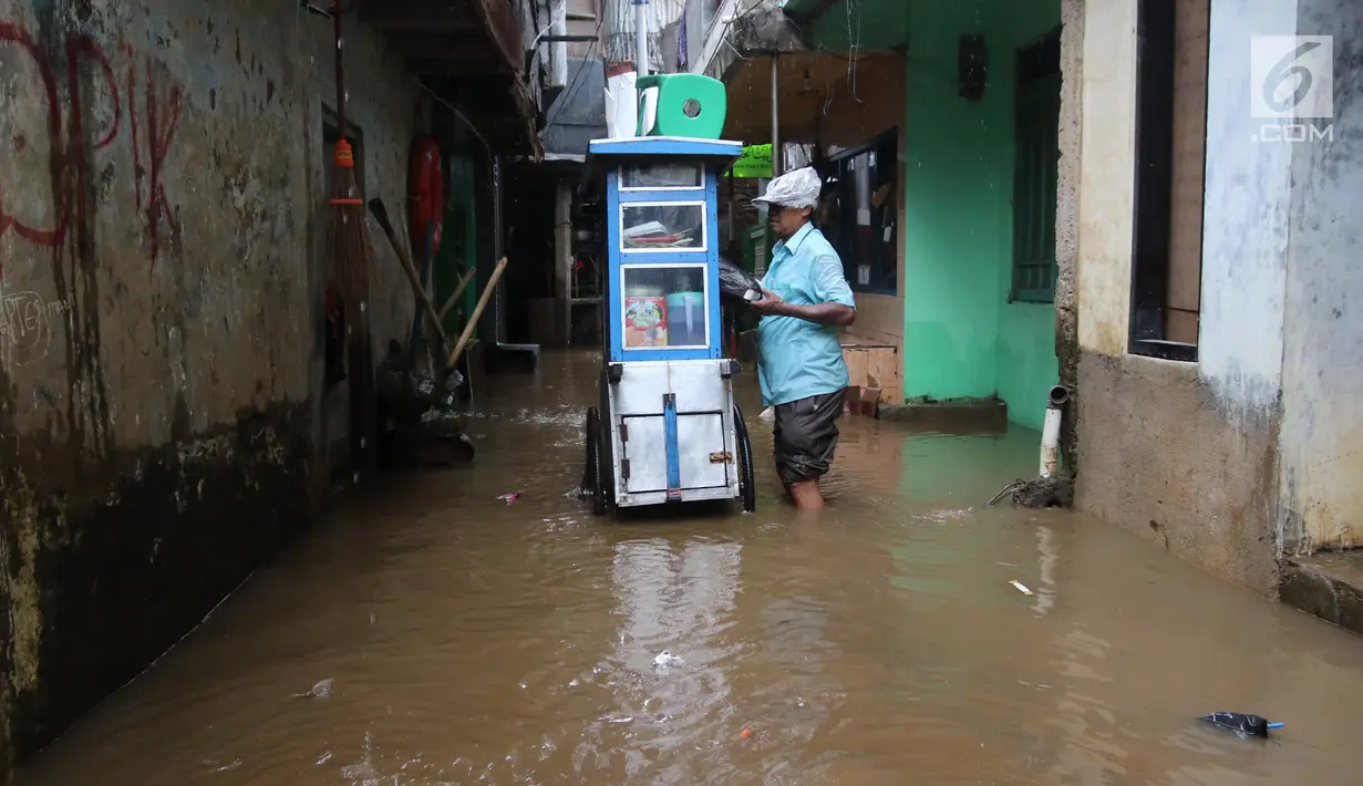 Seorang pedagana berjualan saat banjir melanda Kampung Melayu, Jakarta Timur, Senin (25/6). Banjir tertinggi di Kampung Melayu terjadi di RT 12/04, RT 13/04, RT 10/05 serta RT 11/05. (Liputan6.com/Arya Manggala)