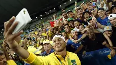 Bintang sepak bola Brasil, Neymar, berfoto bersama pendukungnya setelah meraih emas sepak bola Olimpiade Rio 2016 setelah mengalahkan Jerman di final, (20/8/2016). (AFP/Odd Andersen)