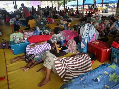 Warga yang mengungsi akibat konflik antara Thailand dan Kamboja beristirahat di pusat evakuasi sementara di dalam sebuah kuil Buddha di provinsi perbatasan Thailand, Si Sa Ket, pada 26 Juli 2025. (Lillian SUWANRUMPHA/AFP)