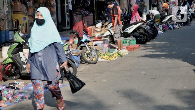 Aktivitas perdagangan dengan menerapkan physical distancing  di halaman Pasar Perumnas Klender, Jakarta, Kamis (18/6/2020). Selain sistem ganjil genap kios, pengelola pasar menerapkan physical distancing antarlapak untuk mencegah penularan COVID-19. (merdeka.com/Iqbal S. Nugroho)