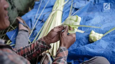 Pedagang sedang menganyam kulit ketupat di Pasar Palmerah, Jakarta, Rabu (2/6). Jelang lebaran penjualan kulit ketupat mulai ramai, omsetnya melonjak hingga 10 kali lipat. (Liputan6.com/Faizal Fanai)