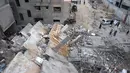 Serangan Israel ini diluncurkan meski perjanjian gencatan senjata antara kedua pihak berseteru masih berlaku. Tampak dalam foto, warga Palestina yang mengungsi memeriksa kerusakan setelah pesawat Israel menargetkan sebuah rumah berlantai lima tadi malam, di Khan Yunis, Jalur Gaza selatan, pada Kamis 6 Februari 2026. (Bashar Taleb/AFP)