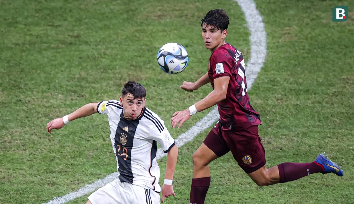 Pemain Timnas Jerman U-17, Bilal Yalcinkaya (kiri) berusaha menerima bola di udara dibayangi pemain Timnas Venezuela U-17 dalam laga pamungkas Grup F Piala Dunia U-17 2023 yang berlangsung di Jakarta International Stadium (JIS), Jakarta, Sabtu (18/11/2023). (Bola.com/Bagaskara Lazuardi)
