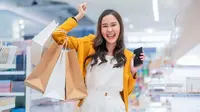 Seorang wanita belanja dengan gembira. (Shutterstock/WHYFRAME)