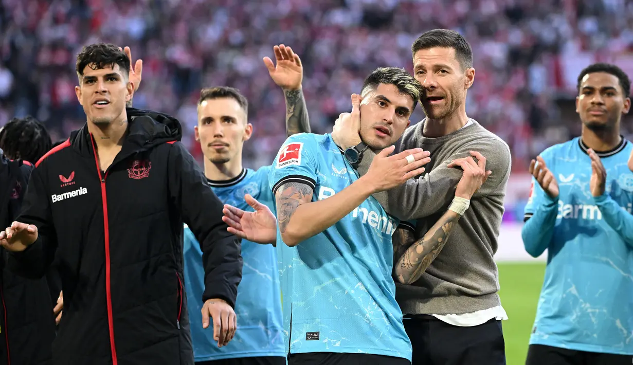 Pelatih Bayer Leverkusen, Xabi Alonso memeluk pemainnya Exequiel Palacios (tengah) setelah laga lanjutan Bundesliga melawan FC Cologne di Cologne, Jerman, 3 Maret 2024. (AFP/Ina Fassbender)