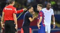Pelatih Barcelona, Xavi Hernandez memberi instruksi kepada pemainnya, Gavi di sela pergantian pemain saat menghadapi Sevilla pada laga pekan ke-8 Liga Spanyol 2023/2024 di Olympic Stadium, Montjuic, Barcelona, Sabtu (30/9/2023) dini hari WIB. (AFP/Pau Barrena)