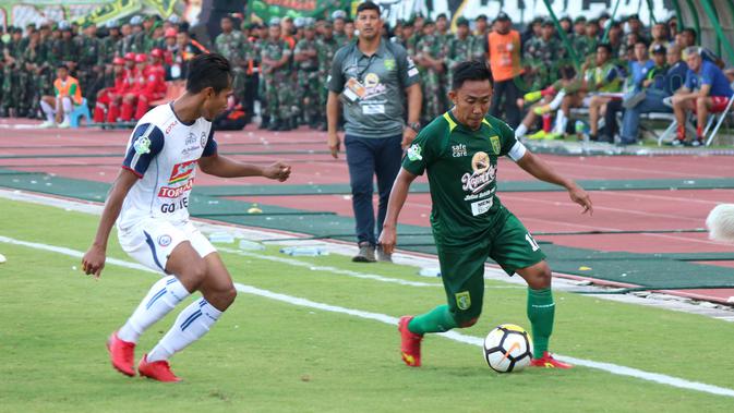 Kapten Persebaya Surabaya, Rendi Irwan (kanan) mencoba melewati adangan pemain Arema FC, Hendro Siswanto pada lanjutan Liga 1 Indonesia 2018 di Stadion Gelora Bung Tomo, Surabaya (6/5/2018). Persebaya Surabaya menang tipis 1-0. (Bola.com/Aditya Wany)