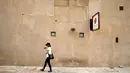 Seorang turis berjalan melewati sebuah bangunan tua di Al Bastakiya, sebuah tempat bersejarah di Dubai, UAE 7 Maret 2016. Dubai menjaga keindahan bangunan-bangunan bersejarahnya agar tetap memiliki pesona yang luar biasa. (REUTERS/Ahmed Jadallah)