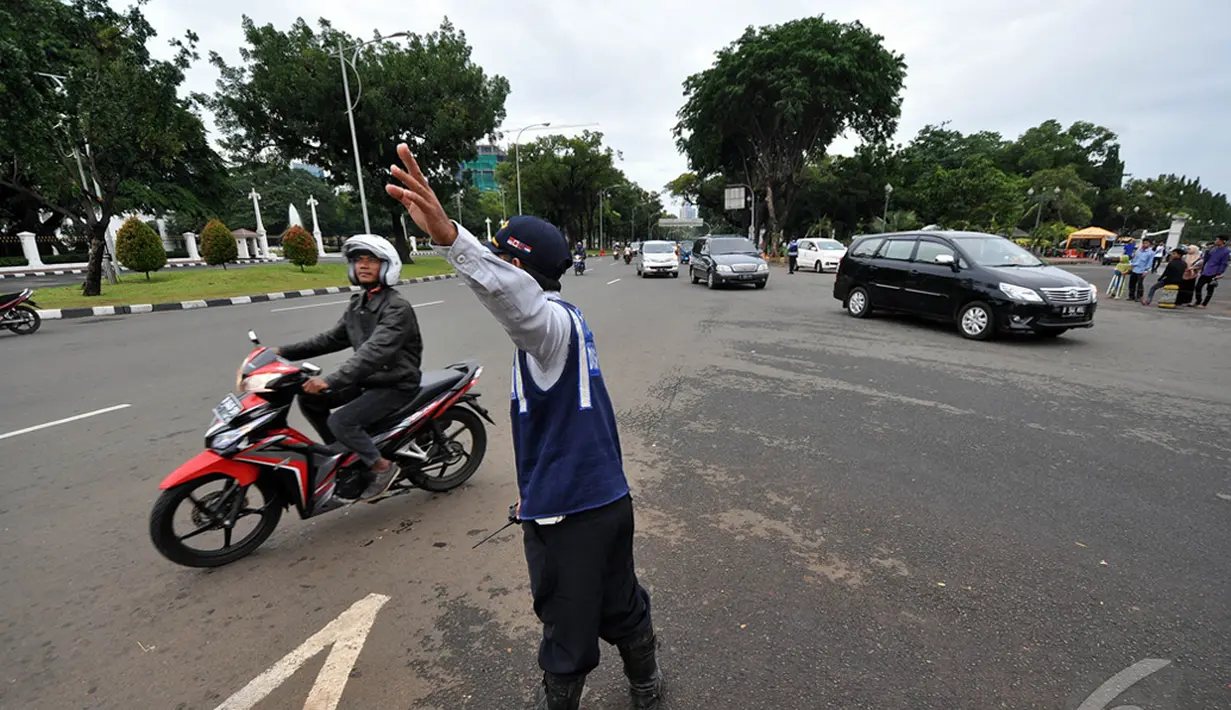  Petugas saat memberikan petunjuk kepada pengendara roda dua untuk tidak melintasi Jl Merdeka Barat untuk memasuki kawasan Monas,  Jakarta, Kamis (1/1/2015). ( Liputan6.com/Miftahul Hayat)