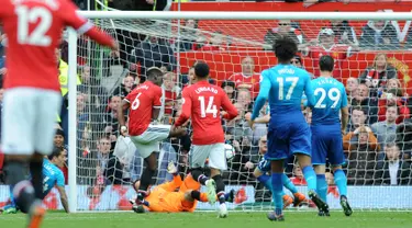 Pemain Manchester United Paul Pogba berhasil mencetak gol ke gawang Arsenal saat pertandingan Liga Inggris di stadion Old Trafford di Manchester (29/4). Manchester United mengalahkan Arsenal 2-1 pada pekan ke-36 Premier League. (AP Photo / Rui Vieira)