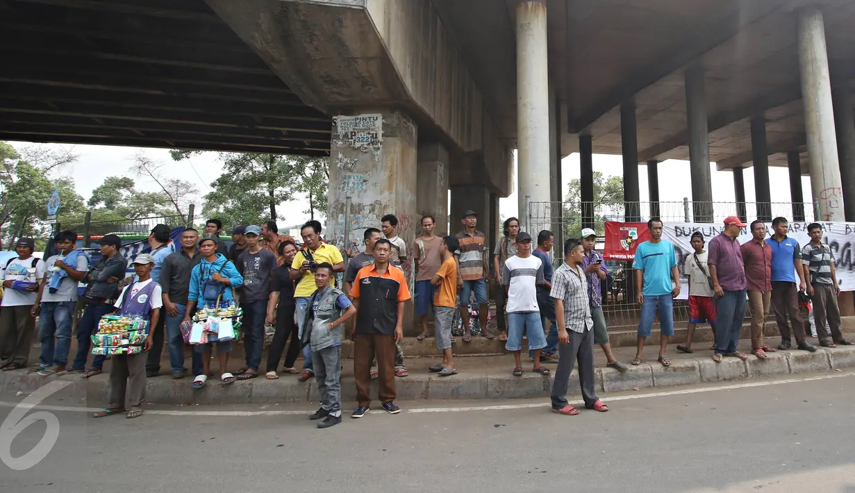 Warga berdiri di depan spanduk penolakan sampah DKI Jakarta di Jalan Raya Narogong, Bogor Timur, Jawa Barat, Rabu (4/11/2015).  Ormas dan warga menyatakan akan tetap menolak truk sampah yang melintas di kawasan tersebut. (Liputan6.com/Immanuel Antonius)