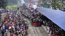 Ratusan penumpang duduk di atas atap kereta untuk menuju kampung halaman di Dhaka, Bangladesh pada 4 Juni 2019. Sebagaimana terjadi di Indonesia, masyarakat Bangladesh pun memiliki tradisi mudik saat Idul Fitri, namun agak membahayakan keselamatan. (MUNIR UZ ZAMAN/AFP)