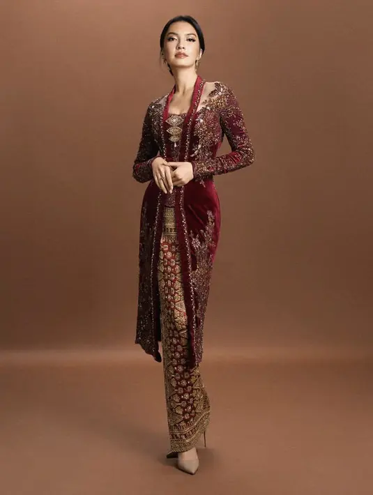 Raline Shah tampil begitu menawan mengenakan kebaya panjang velvet warna merah berbordir, dipadukan kain warna merah keemasan. [@ralineshah]