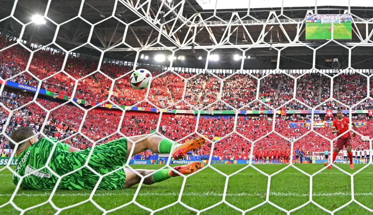 Kiper Inggris, Jordan Pickford (kiri) berhasil menebak arah tendangan pemain Swiss, Manuel Akanji pada babak adu penalti laga perempat final Euro 2024 di Duesseldorf Arena, Duesseldorf, Jerman, Sabtu (06/07/2024). (AFP/Ina Fassbender)