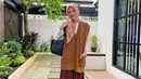 Tampil kekinian dengan padu padan vest tunik dan kemeja bersama rok plisket. Untuk hijab, kamu bisa pilih warna yang lebih terang seperti cream (Instagram/xolovelyayana).