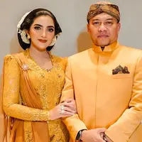 Ashanty dan Anang Hermansyah tampil serasi dalam balutan busana berwarna mustard. Lengkap memakai sanggul, pesona elegan dan anggun kian terpancar dari penampilan Ashanty. (Liputan6.com/IG/@ashanty_ash)