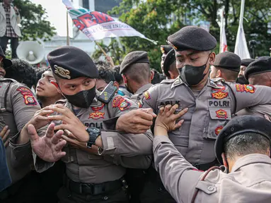 Aparat kepolisian saat terlibat saling dorong dengan massa aksi dari BEM Seluruh Indonesia (BEM SI) di kawasan Patung Kuda, Jakarta, Jumat (28/10/2022). Dalam aksinya mereka menuntut penolakan kenaikan harga BBM hingga penyelesaian pelanggaran HAM masa lalu. (Liputan6.com/Faizal Fanani)