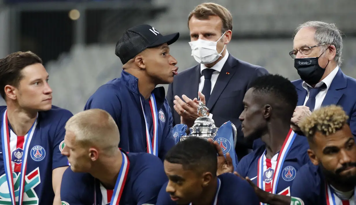Presiden Prancis Emmanuel Macron (tengah) bertepuk tangan saat pemain PSG Kylian Mbappe (kiri tengah) berjalan melewati trofi Piala Prancis usai mengalahkan Saint-Etienne pada laga final di Stade de France, Saint Denis, Paris, Prancis, Jumat (24/7/2020). PSG menang 1-0. (AP Photo/Francois Mori)