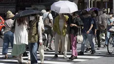 Orang-orang berjalan di atas penyeberangan pejalan kaki di bawah terik matahari di Tokyo, Senin (30/5/2022). Cuaca panas pada hari Senin telah ditetapkan dengan suhu naik lebih dari 27 derajat Celcius (80,6 derajat Fahrenheit) di Tokyo, menurut Badan Meteorologi Jepang. (AP Photo/Eugene Hoshiko)
