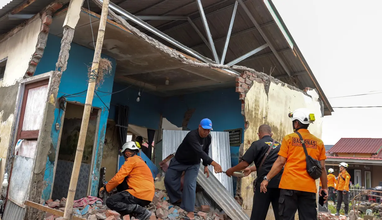 Tim penyelamat membantu penduduk mencari barang-barang berbobot dari reruntuhan rumah mereka nan rusak akibat gempa bumi berkekuatan magnitudo 6,3 di Kelurahan Betungan, Provinsi Bengkulu pada Jumat 23 Mei 2025. (DIVA MARHA/AFP)