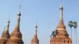 Relawan membersihkan pagoda Buddha kuno di Naypyitaw, Myanmar (27/1). Pagoda yang berada di ibu kota negara tersebut dibangun 160 tahun lalu pada masa dinasti Konbaung dan Amarapura. (AP Photo/Aung Shine Oo)