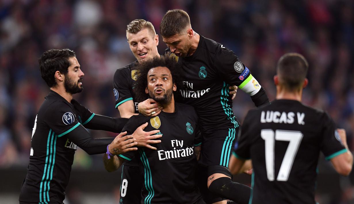 Pemain Real Madrid, Marcelo mendapat ucapan dari rekan timnya usai mencetak gol ke gawang Bayern Munchen pada leg pertama semifinal Liga Champions di Allianz Arena, Rabu (25/4). Real Madrid berhasil menumbangkan Bayern Munchen 2-1. (Sven Hoppe/dpa via AP)