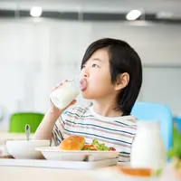 ilustrasi anak minum susu/By milatas from Shutterstock