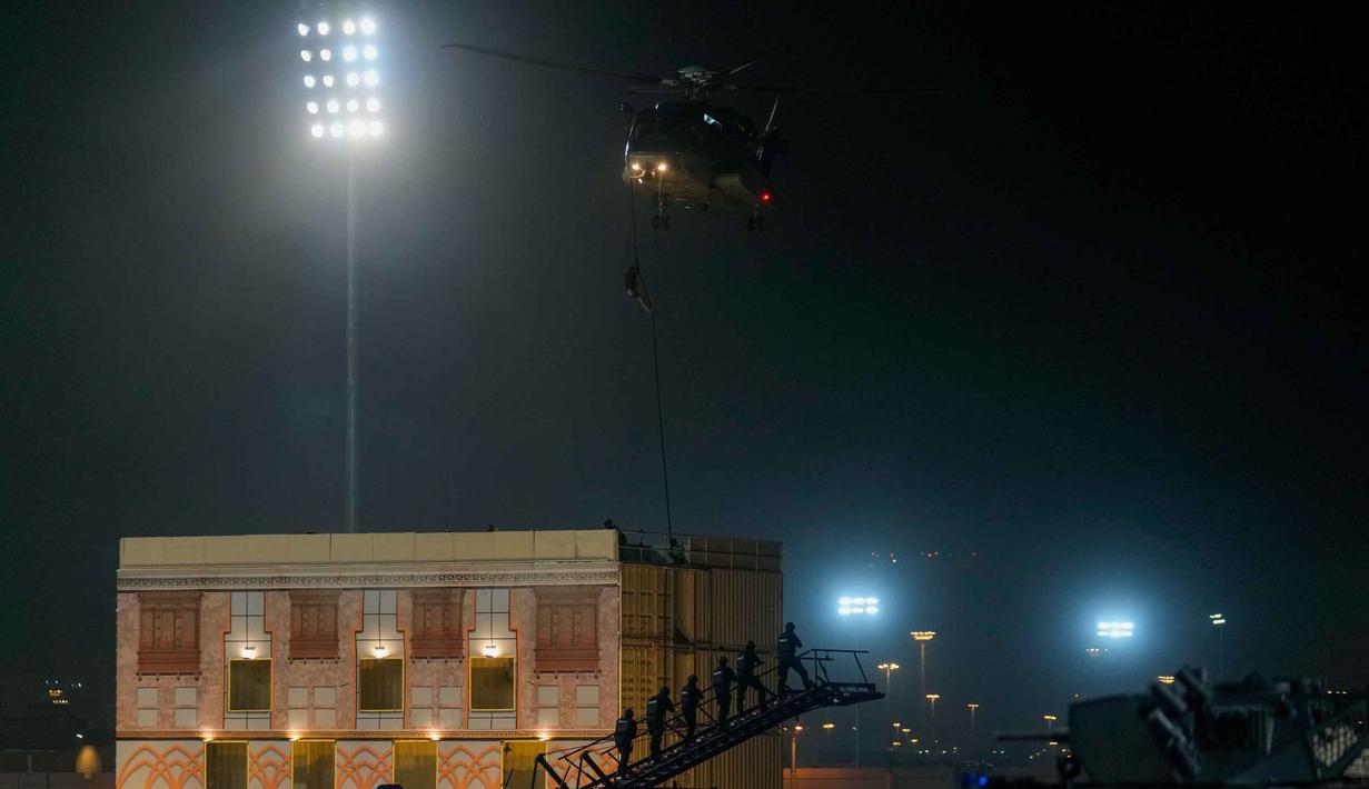 Para anggota pasukan khusus Saudi melakukan pertunjukan selama parade militer dalam persiapan pengamanan ibadah haji, di Mekah, Arab Saudi, Kamis 21 Mei 2026. (AP Photo/Altaf Qadri)