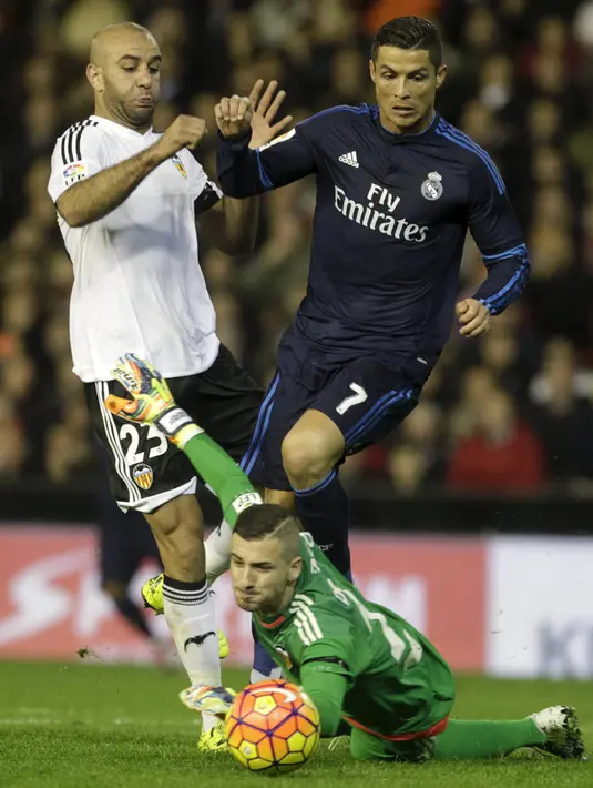 Cristiano Ronaldo (atas kanan) berusaha merebut bola dari pemain Valencia, Aymen Abdennour  dan Jaume Domenech pada lanjutan liga Spanyol di stadion Mestalla, (3/1/2015). Real Madrid bermain imbang dengan Valencia dengan skor 2-2. (REUTERS/Heino Kalis)